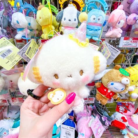 a person holding a small stuffed animal in front of a bunch of other stuffed animals