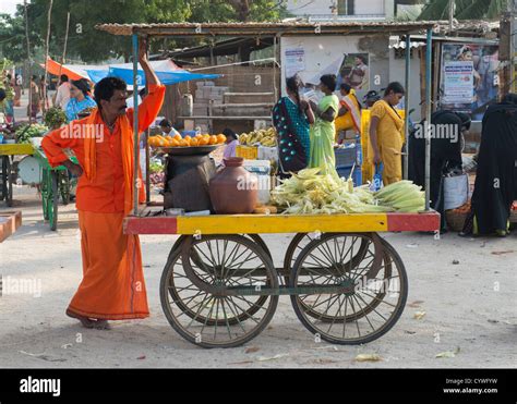 Indian man street vendor selling cooked corn on the cob at a street ...