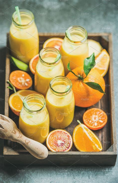 Healthy yellow smoothie in bottles in wooden tray containing smoothie, fruit | Healthy food ...