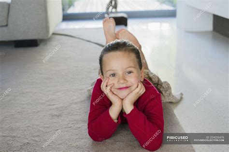 Portrait of smiling little girl lying on carpet at home — childhood, feet up - Stock Photo ...