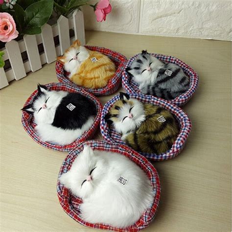 four cats sleeping in small pet beds on a table