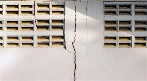 Premium Photo | Cracks in the cement wall white cement of buildings damaged by earthquakes