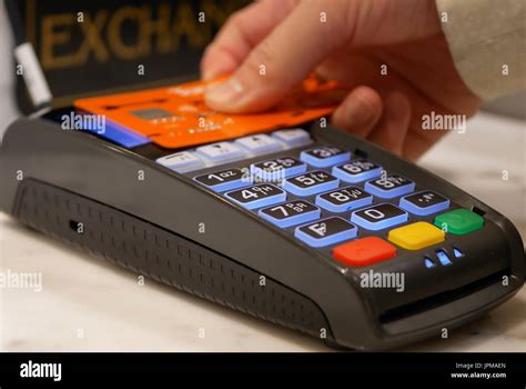 Woman tapping credit card on payment terminal Stock Photo: 151652669 - Alamy