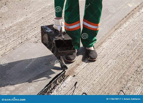 The Man Working Asphalt Pouring Tar For Road Repair. Stock Image ...