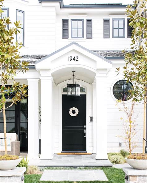 There's something so endearing about a white home with a black door and ...