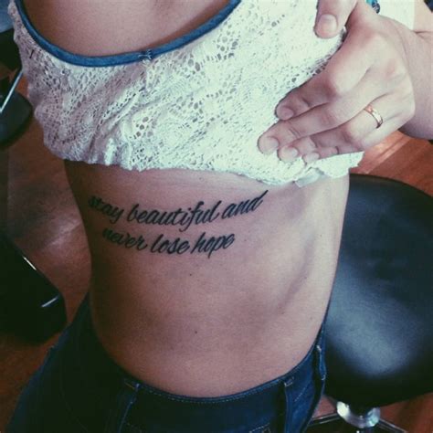 Side tattoo saying "Stay beautiful and never lose hope"