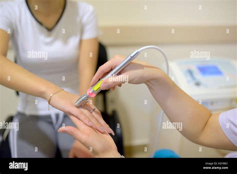 Young woman receiving laser therapy on wrist hand Stock Photo - Alamy