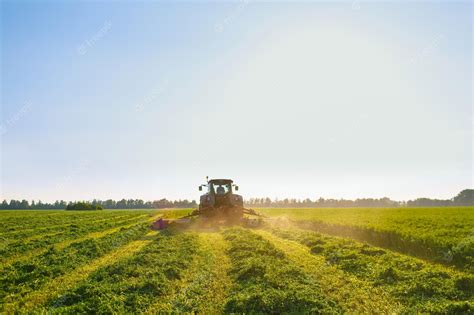 Premium Photo | Tractor makes harvesting hay for animals on a farm