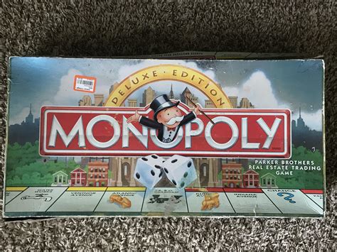 A badly beat up Monopoly Deluxe Edition set. Ever side of the box is in ...