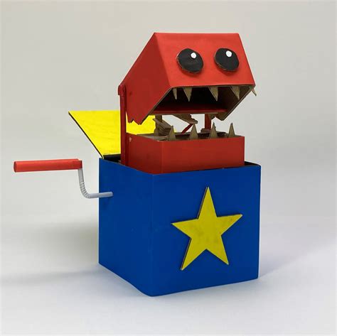 a paper model of a red, yellow and blue box with a monster's head sticking out of it