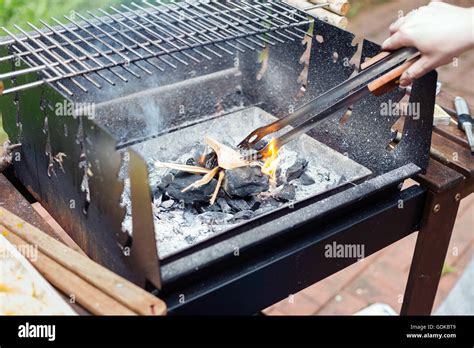 Preparing charcoal grill for a summer barbecue party. Lifestyle image ...