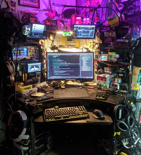 a computer desk with multiple monitors and keyboards on it in a room ...