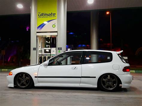 a white car parked in front of a gas station