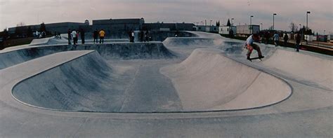 a group of people riding skateboards on top of ramps at a skateboard park