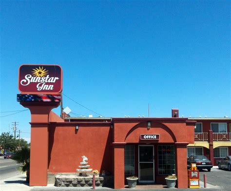 a red building with a fountain in front of it and a sign that says sun ...