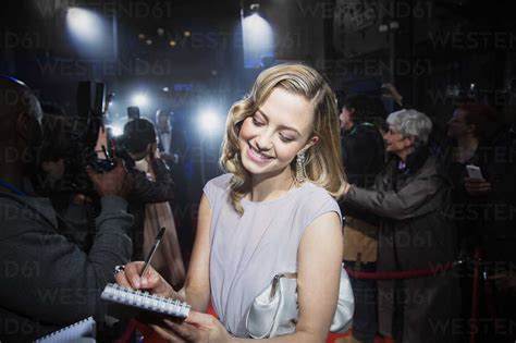 Well dressed female celebrity signing autographs at red carpet event stock photo