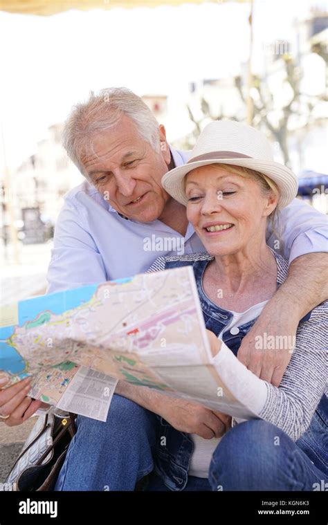 Senior couple of tourists looking at city map Stock Photo - Alamy