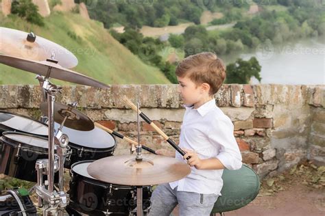 Small kid learning to play drums outdoors. 10909058 Stock Photo at Vecteezy