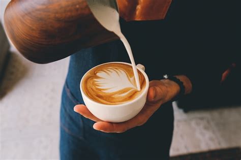 Free Photo | Man pouring milk in coffee latte foam decor