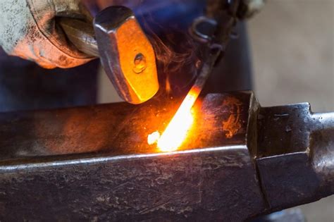 Premium Photo | A blacksmith forging hot iron on the anvil.