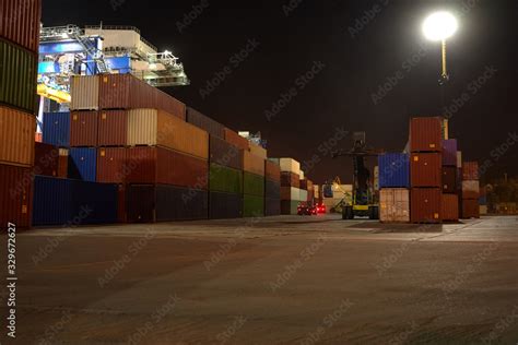 operation of container terminal at night. Unloading container ship at night. Mooring cranes ...