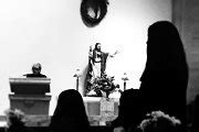 Moody image of a Catholic church mass with a Jesus statue on the altar - Black and White grainy ...