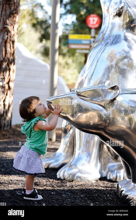 A little girl kisses a statue of a polar bear in the San Diego Zoo, arctic section Stock Photo ...