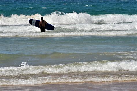 Surfer along Manly Beach at Manly in Sydney, Australia - Encircle Photos