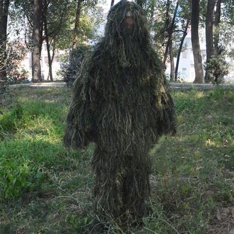 a man in camouflage is standing in the grass