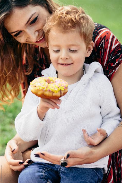 "Mother And Son At A Family Picnic, Eating A Doughnut" by Stocksy ...