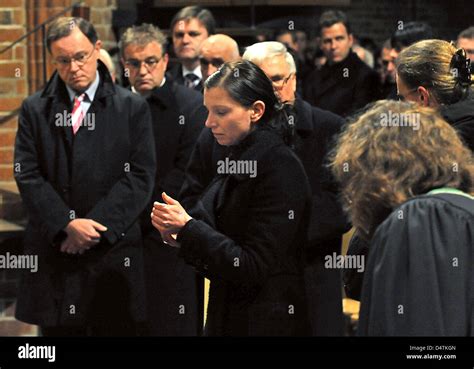 Teresa Enke (2-R), widow of goalkeeper Robert Enke, lights a candle ...