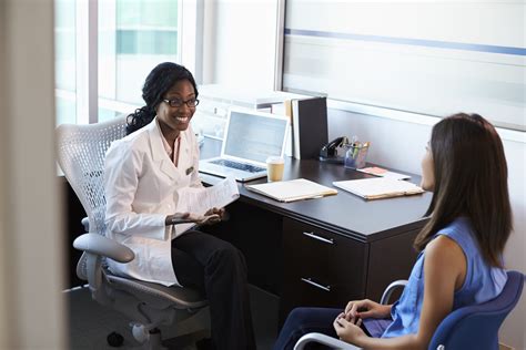 Doctor Wearing White Coat Meeting With Female Patient - Linguava