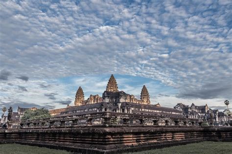 Premium Photo | Giant ancient cambodian temple at sunrise under cloudy sky in angkor complex ...