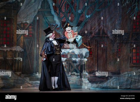 Drosselmeyer carries a Nutcracker doll to children in the ballet the ...