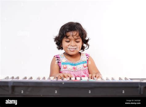 Cute little girl learning piano Stock Photo - Alamy