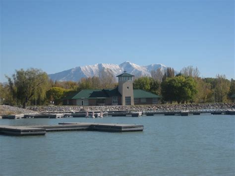 there is a building on the water with mountains in the background