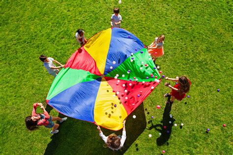 Niños Felices Agitando Paracaídas Arco Iris Lleno De Bolas Foto de stock y más banco de imágenes ...