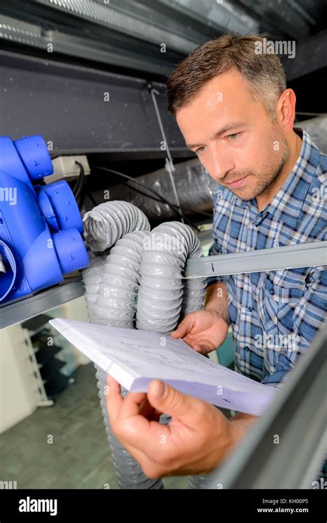 Man installing a new ventilation system Stock Photo - Alamy