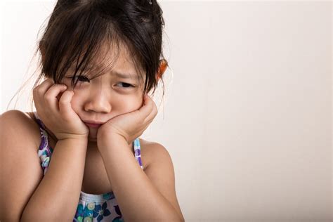 sad little girl with hands on face - Wyoming Department of Health