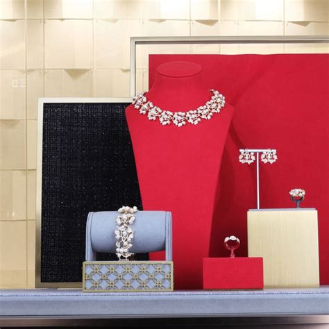 an assortment of jewelry on display in front of a red wall