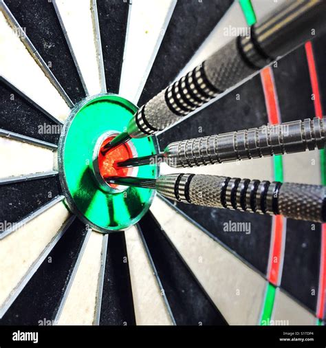 Darts meet bullseye Stock Photo - Alamy