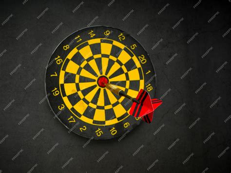 Premium Photo | Dart arrow with board on black granite