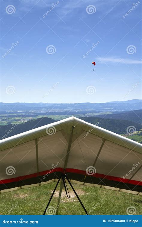 Hang Glider on Ground and a Paraglider in the Air. Stock Photo - Image ...