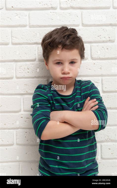 Angry frowning boy on brick wall background Stock Photo - Alamy
