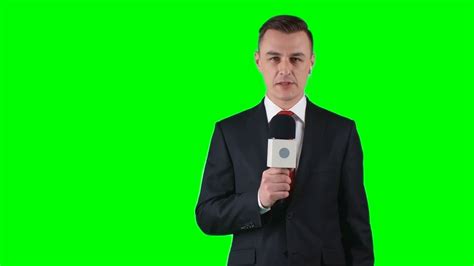 TV journalist standing on green screen background with microphone and ...