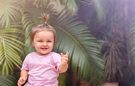 Premium Photo | Portrait of a smiling child with palm leaves