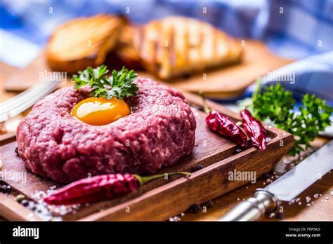 Raw beef .Tasty Steak tartare. Classic steak tartare on wooden board ...