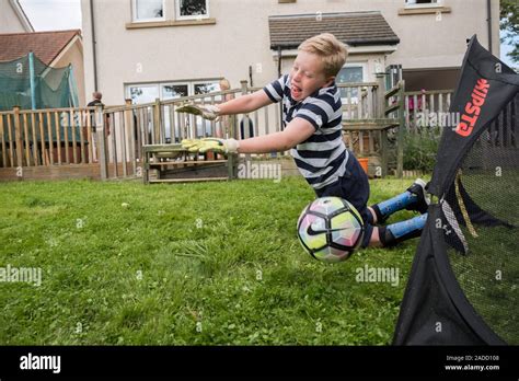 Boy with cerebral palsy. 10-year-old boy with cerebral palsy playing football in his garden ...