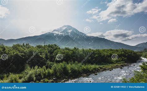 A Volcano With A Snow-capped Peak On The Background Of A Blue Sky With ...