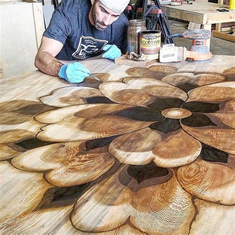 a man is working on wood carvings with paint and glue in front of him at a table